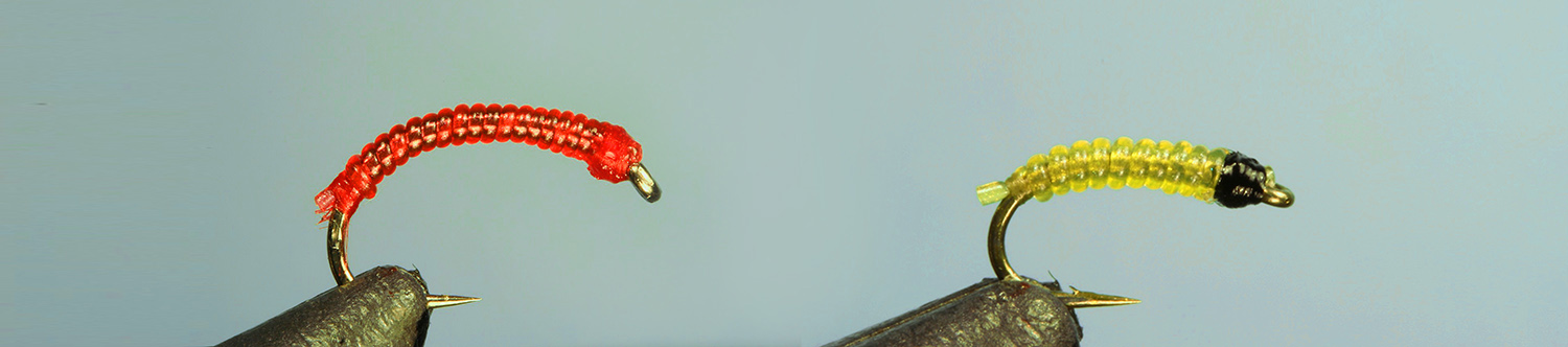 Jelly Bloodworm and Jelly Grub flies side by side on separate vises