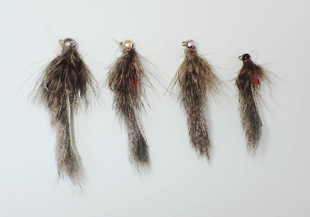 Four jig bully flies on a pale background