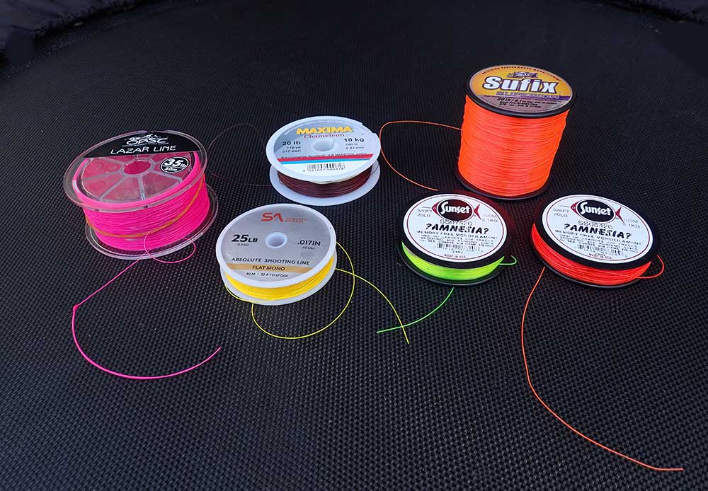 Selection of different brightly coloured lines for mono rig fishing system on a black background