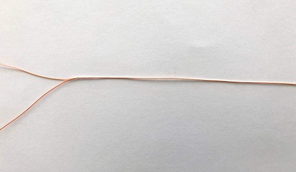 Reverse spliced loop on pale background