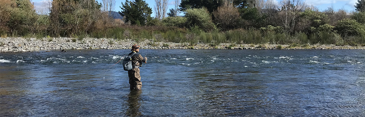 fly fisherman Spey casting with a single hand rod in pool, Tongariro River, New Zealand