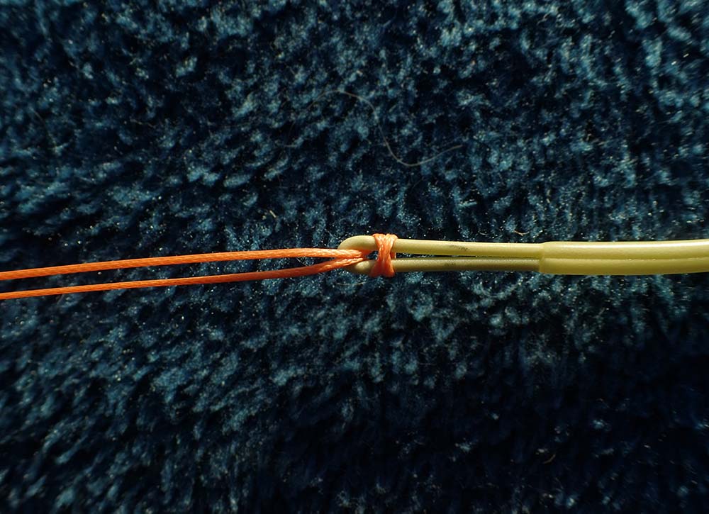 Two passes of spooled line passing the fly line on black background